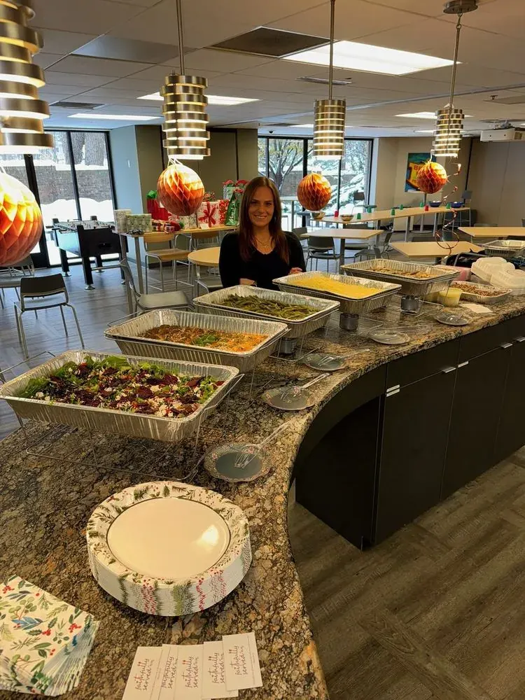 A hot catered lunch laid out on the counter of a workplace break room