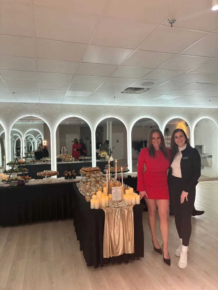 Chef Selena and Mariah beside a styled grazing buffet at an event
