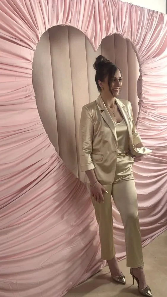 Mariah in front of a blush heart-shaped backdrop styled for a celebration