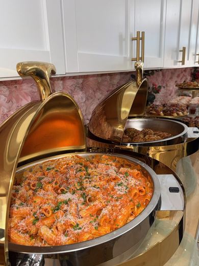 Gold chafing dishes of vodka rigatoni and beef, held hot for service